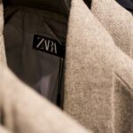 Is Zara fast fashion — close-up of Zara label on tweed jacket in clothing rack