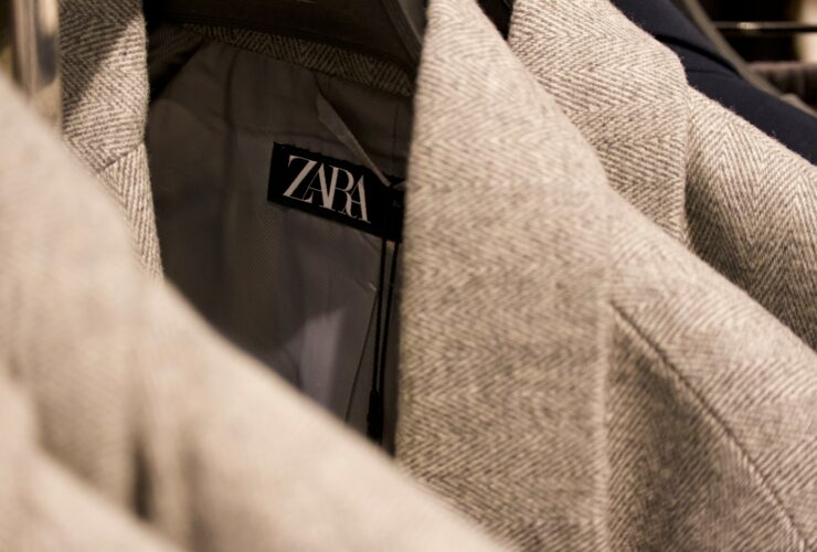 Is Zara fast fashion — close-up of Zara label on tweed jacket in clothing rack