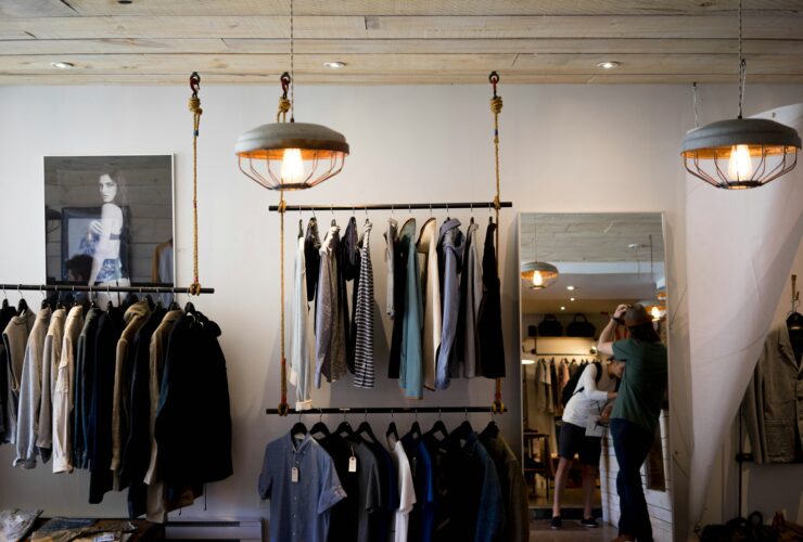 Clothing store interior with shirts and jackets on racks, showing a stylish retail display for top garment brands.