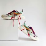 Colorful used designer shoes displayed on a white background.