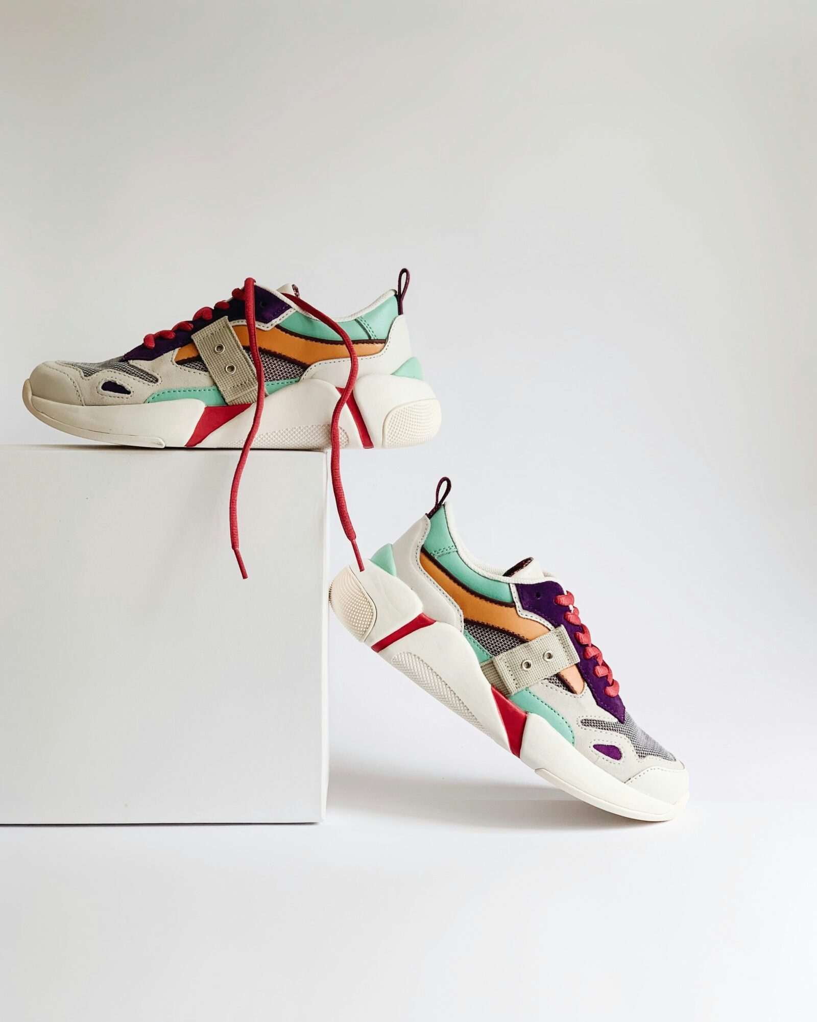 Colorful used designer shoes displayed on a white background.