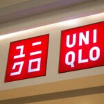 Uniqlo Fast Fashion store signage displaying red illuminated logo with Japanese katakana text on retail storefront