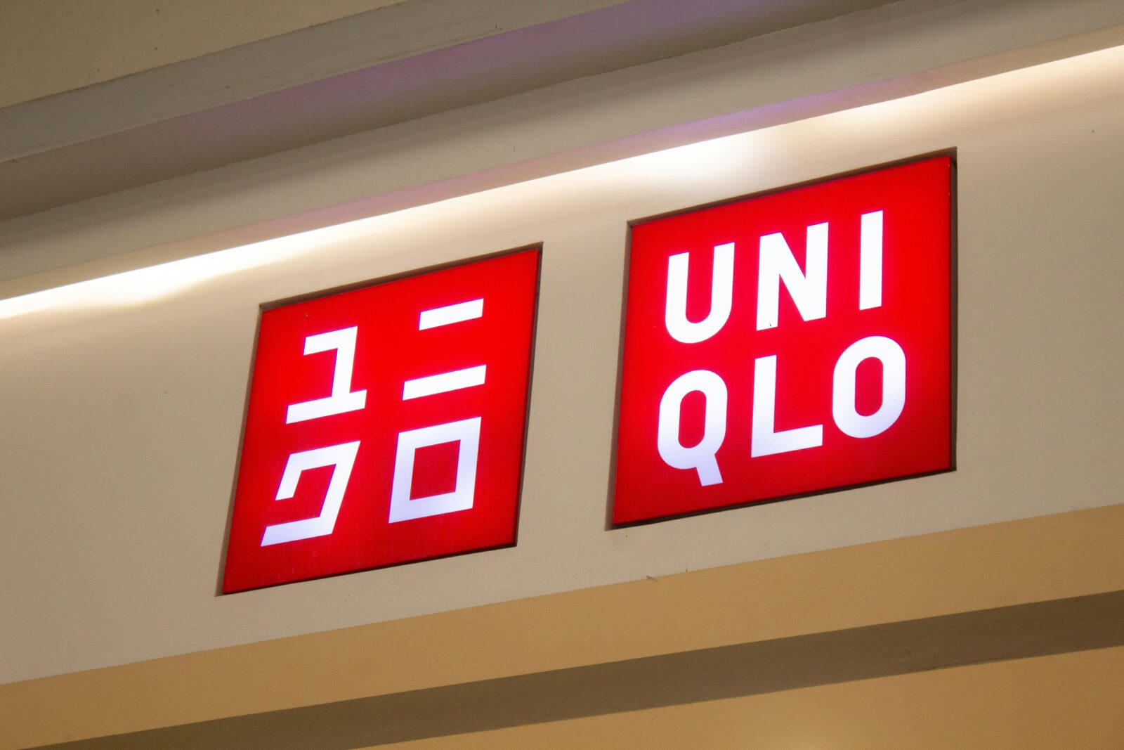 Uniqlo Fast Fashion store signage displaying red illuminated logo with Japanese katakana text on retail storefront