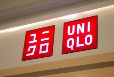Uniqlo Fast Fashion store signage displaying red illuminated logo with Japanese katakana text on retail storefront