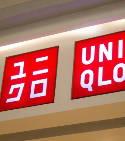 Uniqlo Fast Fashion store signage displaying red illuminated logo with Japanese katakana text on retail storefront